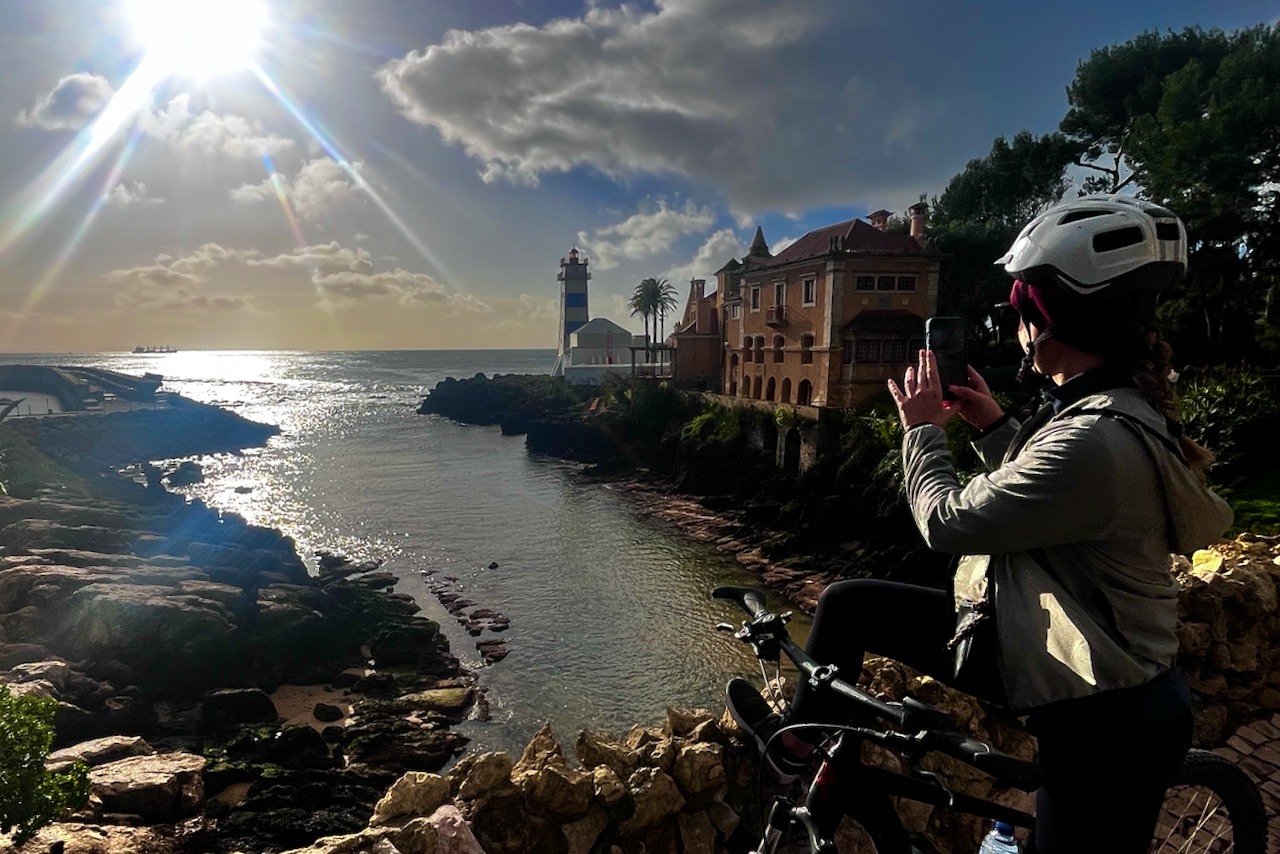 Cyclists exploring Cascais landmarks along the coast — Santa Marta lighthouse, Guincho beach and old town